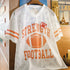 White mesh sports jersey with orange text and football graphic on a hanger.